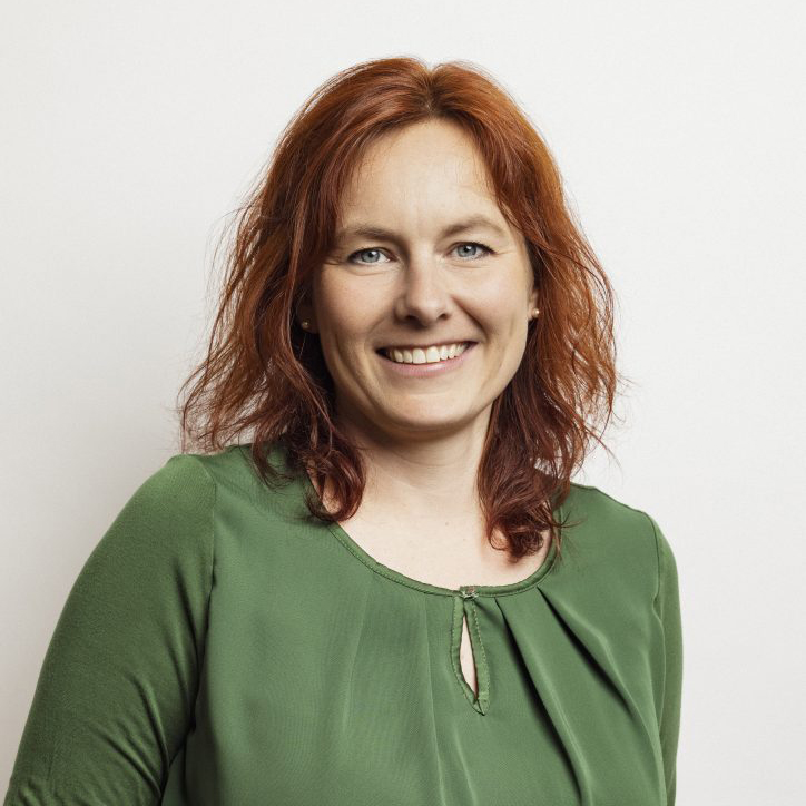 Portraitbild von Kerstin Braun: rötliche, schulterlange Haare, grüne Bluse. Sie lächelt.