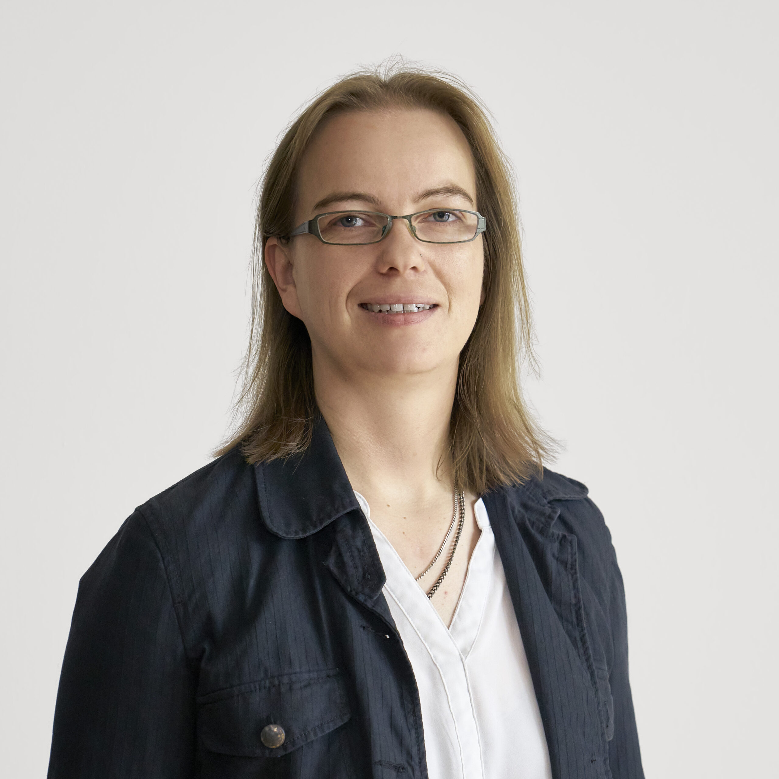 Portraitbild von Kathrin Arnold Tatgenhorst, stellvertretende Leiterin der Wäscherei bei Vinzenz. Sie lächelt in die Kamera.