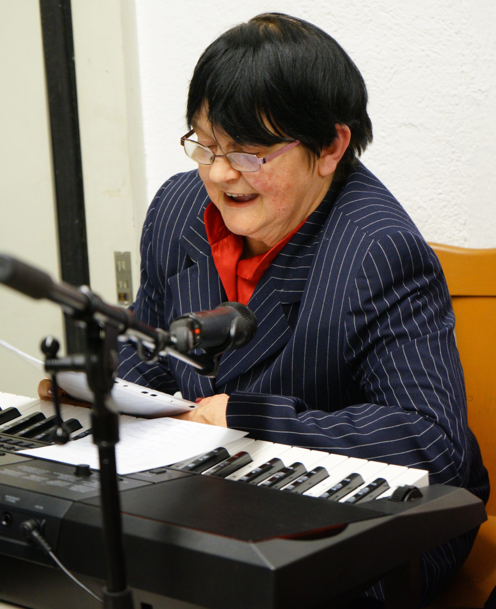 Auf dem Bild ist unsere Kollegin Frau Merz-Trippel an ihrem Keyboard beim Vorlesen einer Weihnachtsgeschichte zu sehen.
