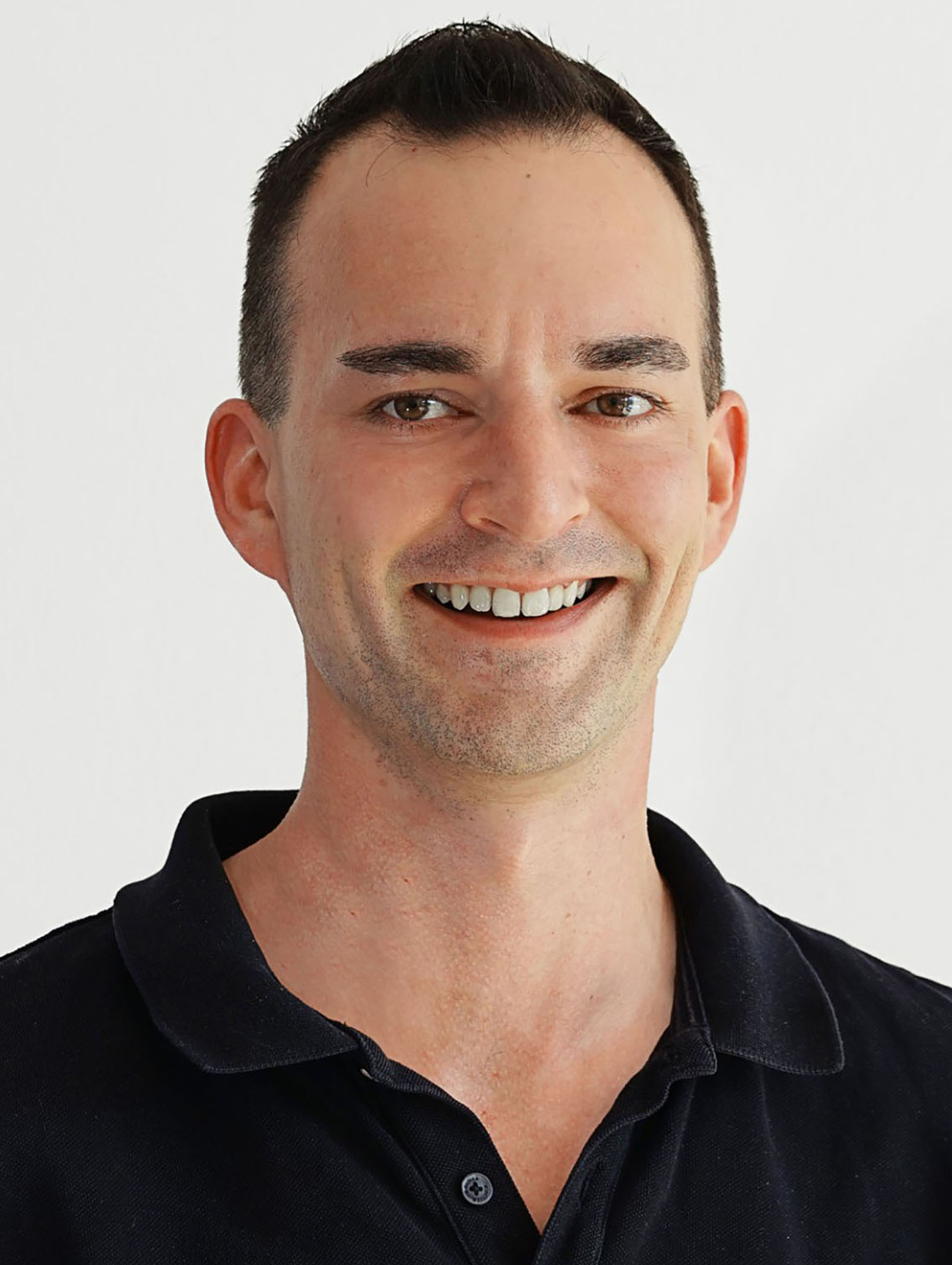 Portrait des Geschäftsführers Michael Herrmann. Er lächelt offen in die Kamera.